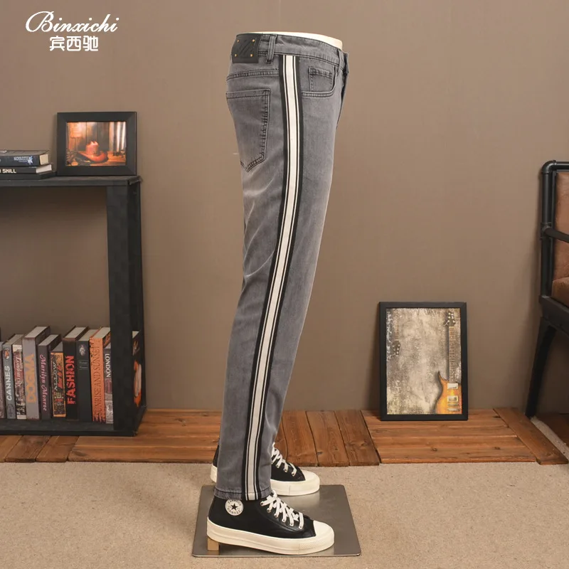 Celana jeans pria 2025 model baru trendi high-end elastis potongan ramping dengan hiasan pita rajutan bergaris