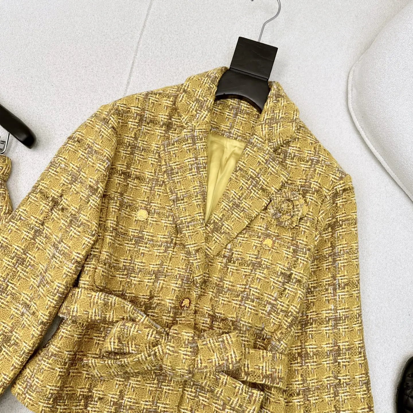 El último conjunto de temperamento de alta sociedad para otoño e invierno de 2025, con chaqueta tejida con decoración floral y falda acampanada.