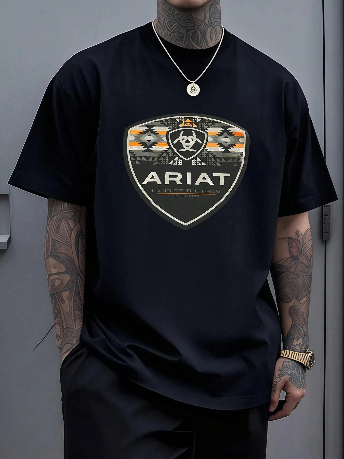 Emblema de escudo para hombre con patrones geométricos que simbolizan la libertad, la herencia y la fuerza, gráfico en camisetas Ariat para hombre.