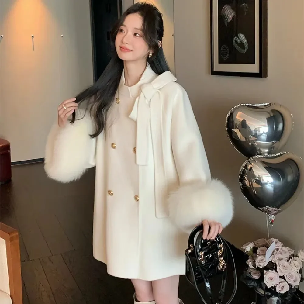 เสื้อโค้ทขนสัตว์ผู้หญิงแบบกระดุมสองแถว คอลเลคชั่นฤดูใบไม้ร่วง-ฤดูหนาว ปี 2025 ผ้าขนสัตว์แท้ แต่งขนจิ้งจอกแท้ พร้อมโบว์ ผ้าแคชเมียร์สองด้าน