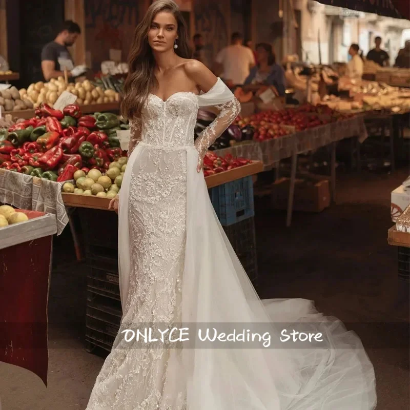 Suknia ślubna w stylu syreny, seksowna, pełna wdzięku, z dekoltem w serduszko, z tiulu w kolorze ecru, z odpinanym trenem.