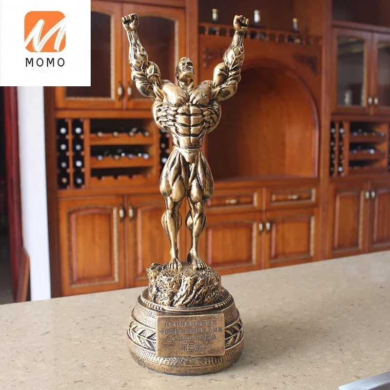 Fitness muscle man sets up bodybuilding sports competition trophies, boxing figures, statues, sculptures, gym decorations