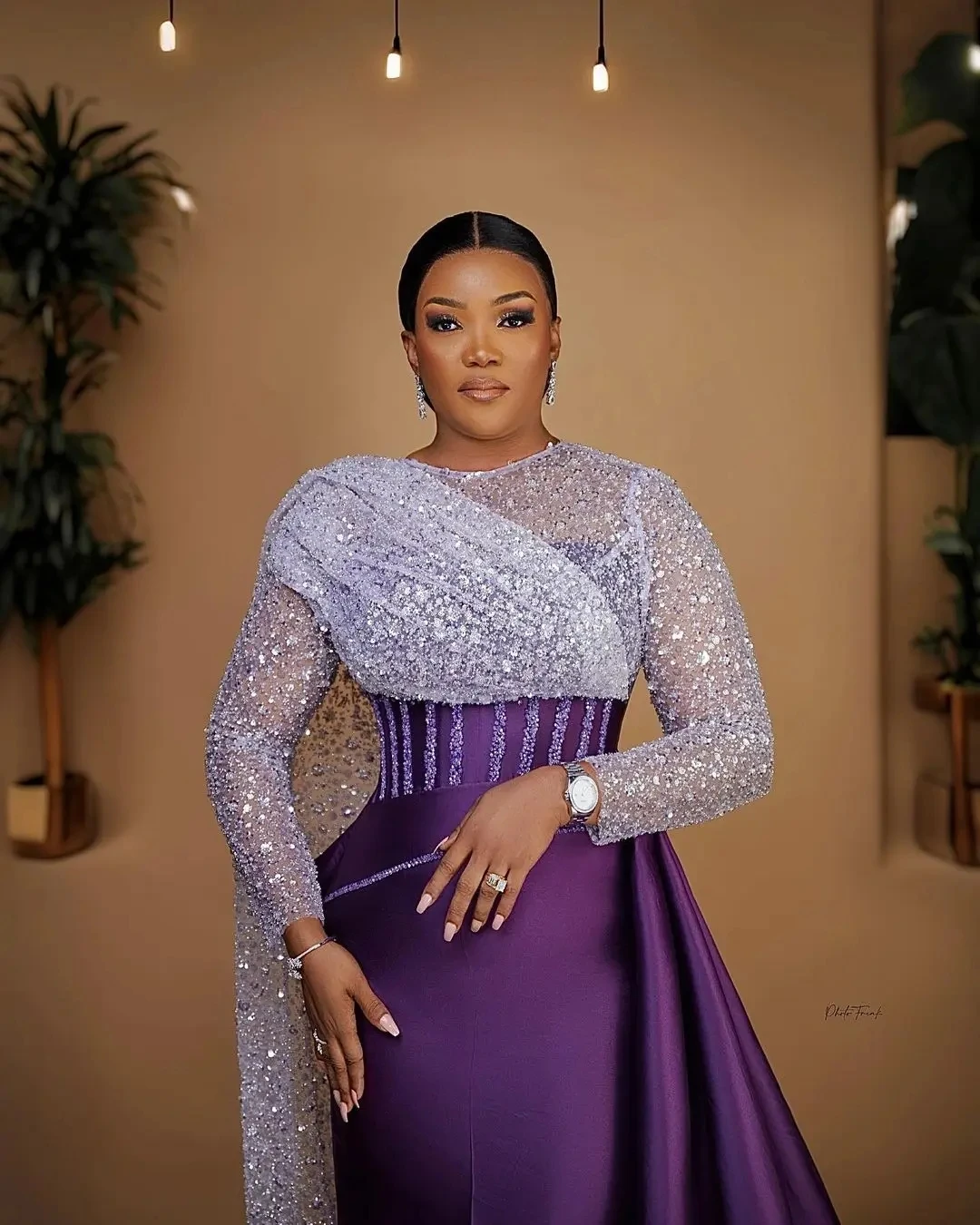 ชุดราตรีทรงเมอร์เมดผ้าซาตินสีม่วงประดับเลื่อมวิบวับและลูกไม้สไตล์แอฟริกัน พร้อมชายกระโปรงยาวด้านข้าง เหมาะสำหรับงานพรอมหรืองานเลี้ยงอย่างเป็นทางการ