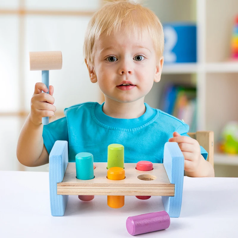 Le jouet de frappe coloré en bois comprend des chevilles colorées assorties et un marteau en bois Les enfants ont un marteau explosif