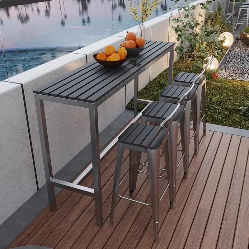 Outdoor plastic wood bar table and chairs, open-air balcony against the wall, long table bar