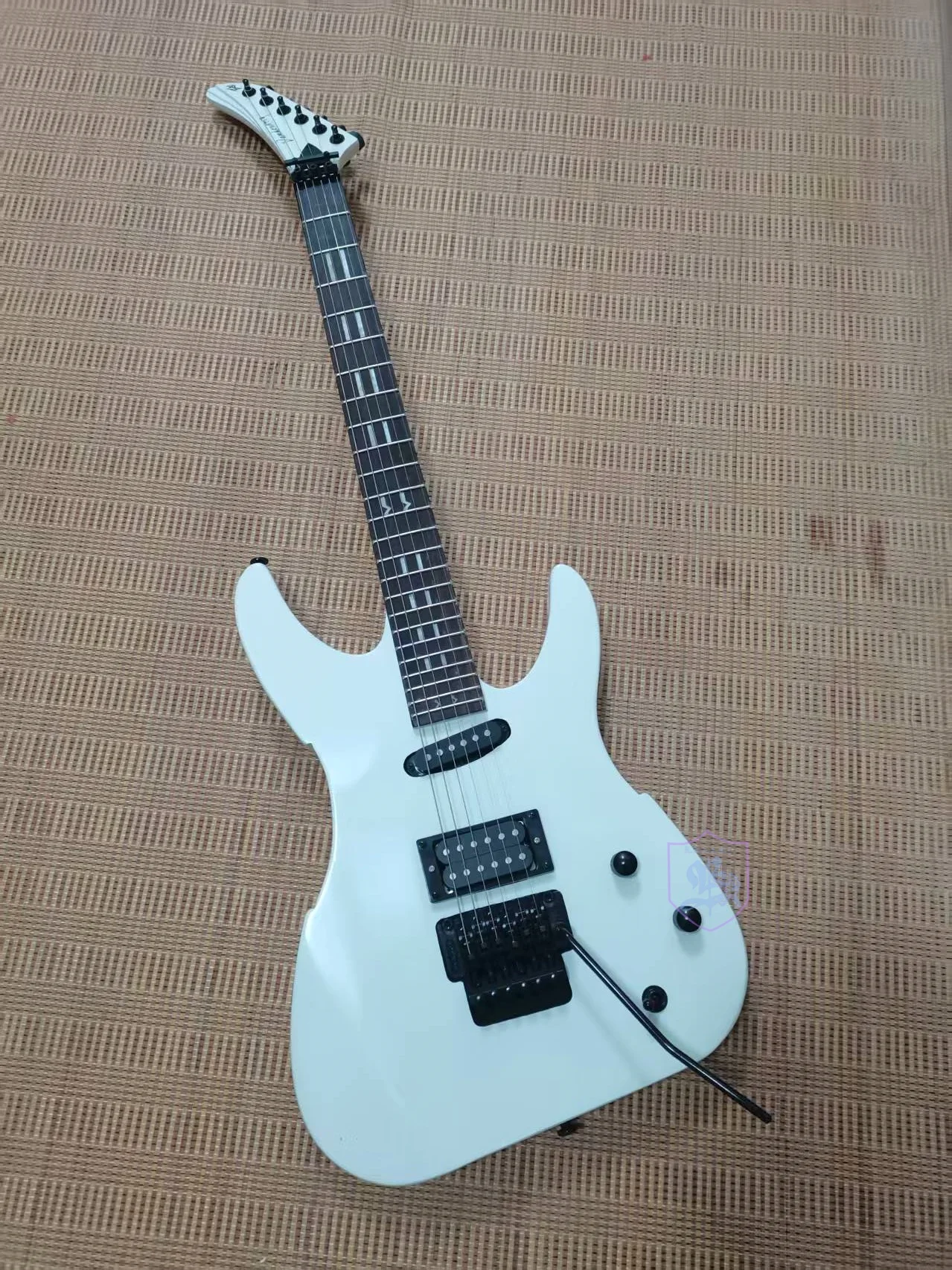 

Электрогитара с 6 струнами, грифом из палисандра, белой глянцевой краской, черными деталями, системой вибрато, совершенно новая.