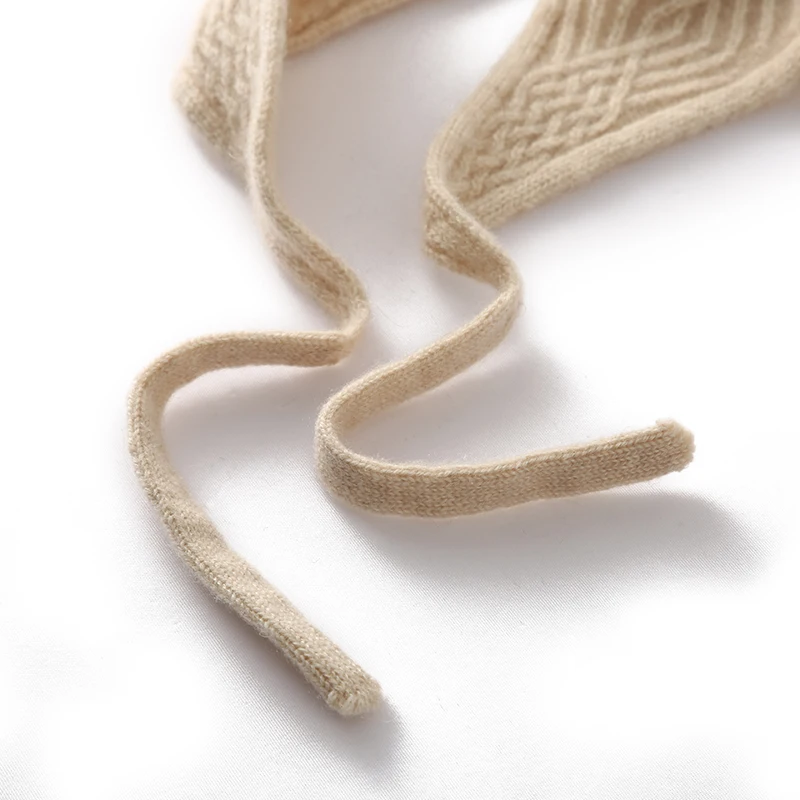 قبعة كرة شعر عصرية للسيدات شتوية سميكة 100% من الكشمير الخالص محبوكة بلون سادة قبعة حماية للأذن دافئة ومقاومة للرياح