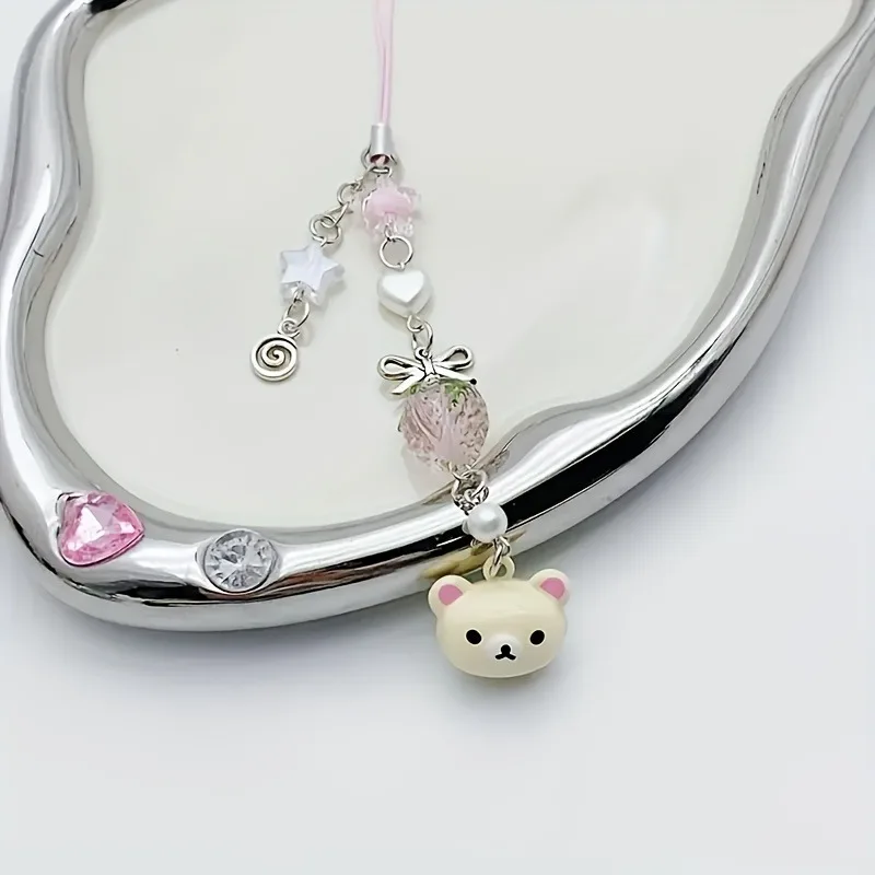 

A cute bear bell, with a bow, decorated with stars and strawberries, suitable for use as a phone charm or bag accessory.