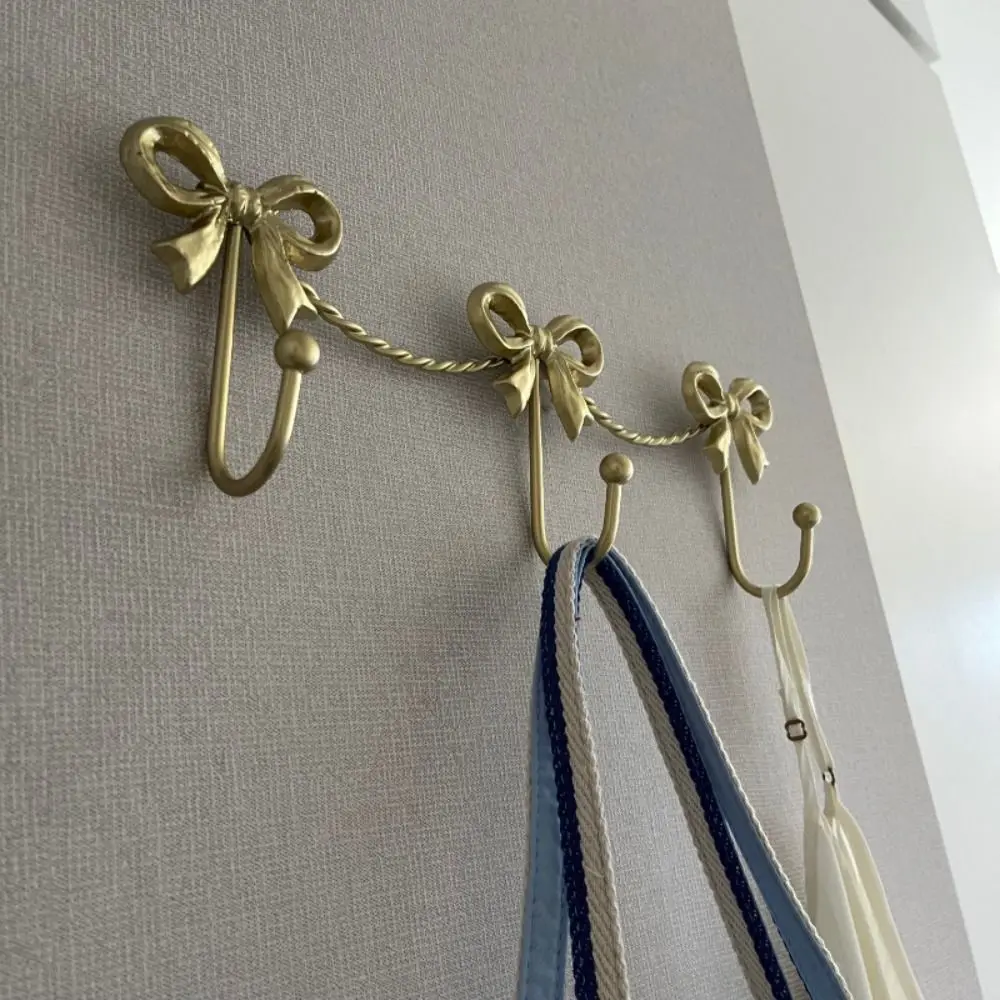 

Golden Finish Metal Bow Wall Hooks Iron Material Smooth Finish Decorative Hangers Sturdy Metal Bow Design Wall Hook Living Room