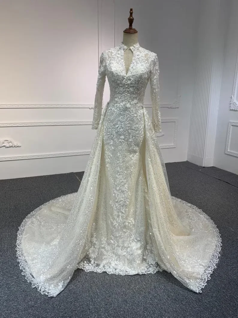 Elegantes Hochzeitskleid im Meerjungfrauen-Stil mit hohem Kragen, maßgefertigt, mit aufwendiger Spitze und Perlenbesatz, abnehmbarer Schleppe und langen Ärmeln, Amanda Novias Official.