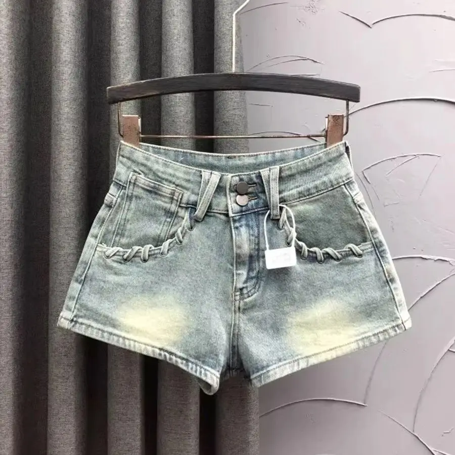 Pantaloncini di jeans vintage 2025 Nuovi pantaloncini a tre divisioni con design a tasca grande in corda intrecciata cava per jeans estivi sexy da donna