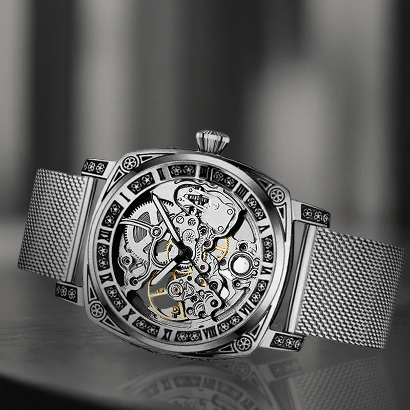 ساعة ميكانيكية أوتوماتيكية بالكامل بحزام شبكي فضي وأنيق على طراز المؤشر وأرقام رومانية للرجال.