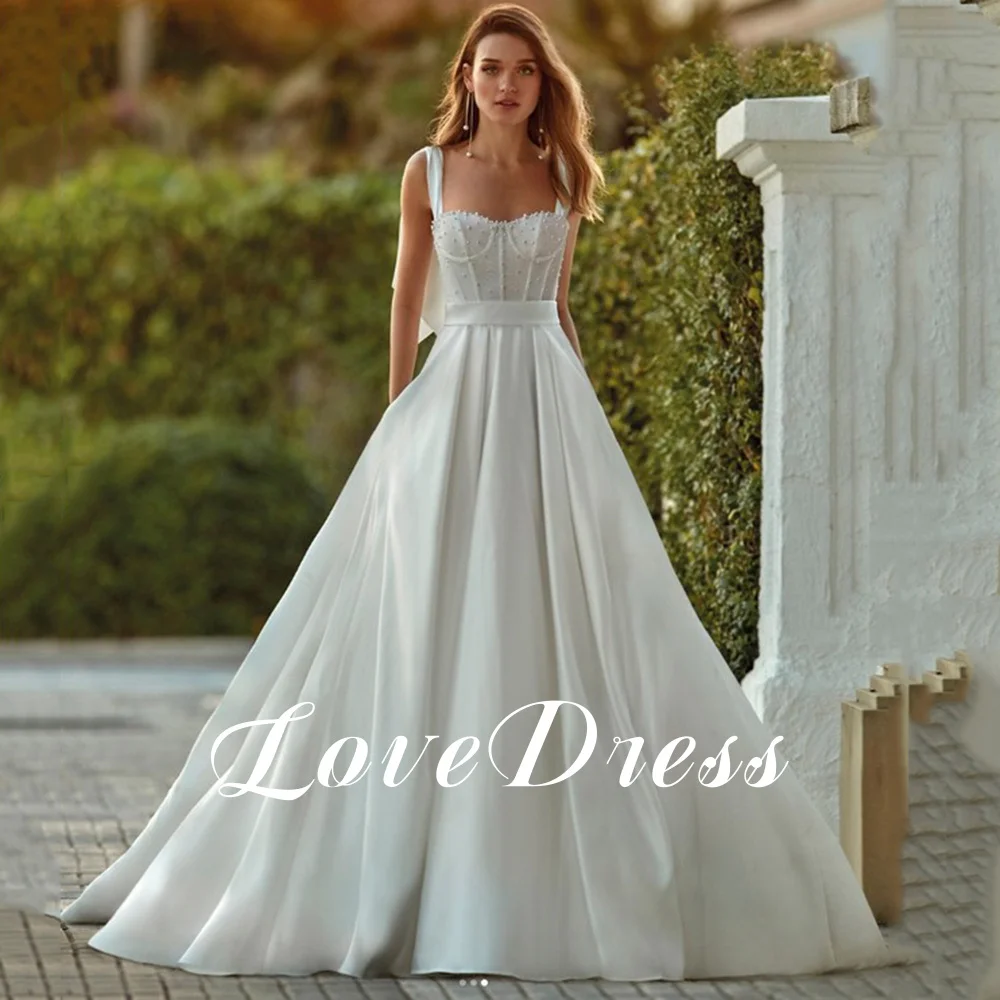 فستان زفاف من LoveDress أبيض عصري على شكل قلب بجيوب بدون أكمام مطرز بفيونكة فستان عروس بسيط من الساتان بدون ظهر بأزرار