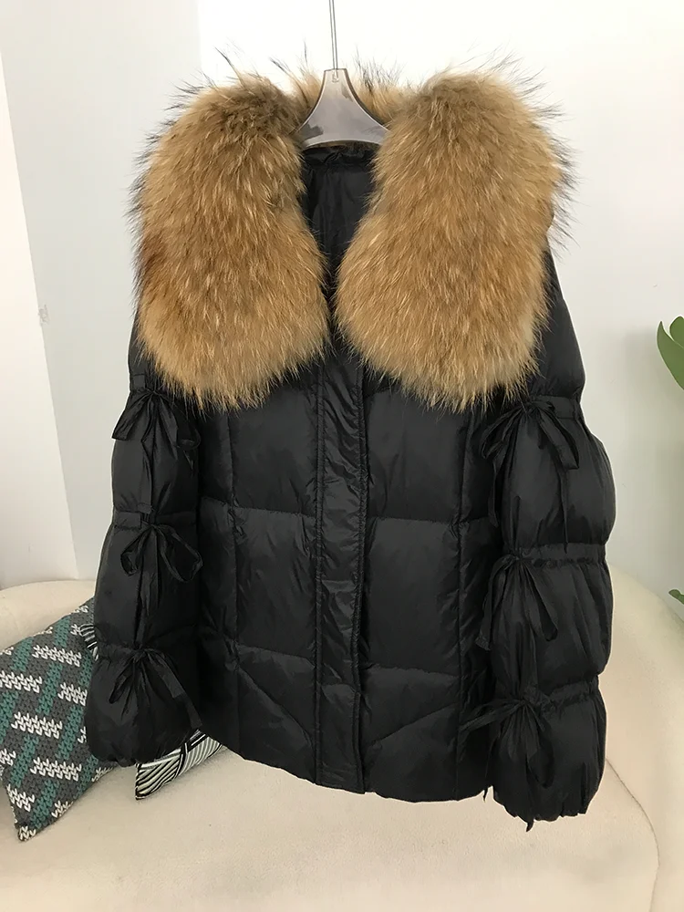 2025 الشتاء النساء بطة أسفل سترة معطف سوبر كبير ريال الراكون الفراء طوق مع ربطة القوس فيونكة كم موضة ملابس خارجية فاخرة