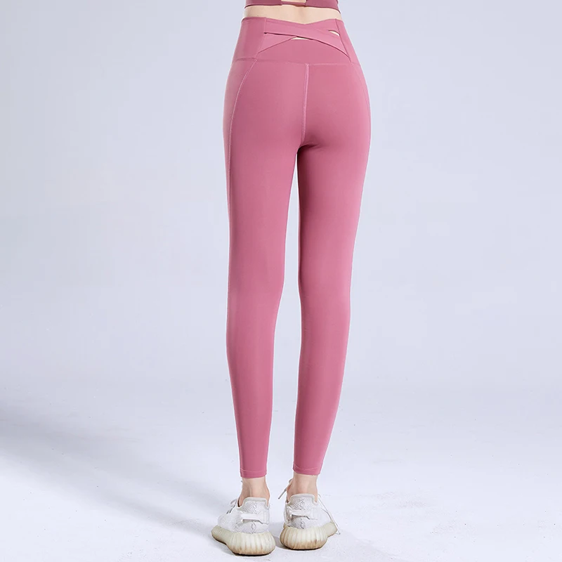 Nuovi pantaloni sportivi ad asciugatura rapida Pantaloni da yoga da corsa attillati Pantaloni da fitness incrociati elasticizzati all'anca color pesca a vita alta da donna