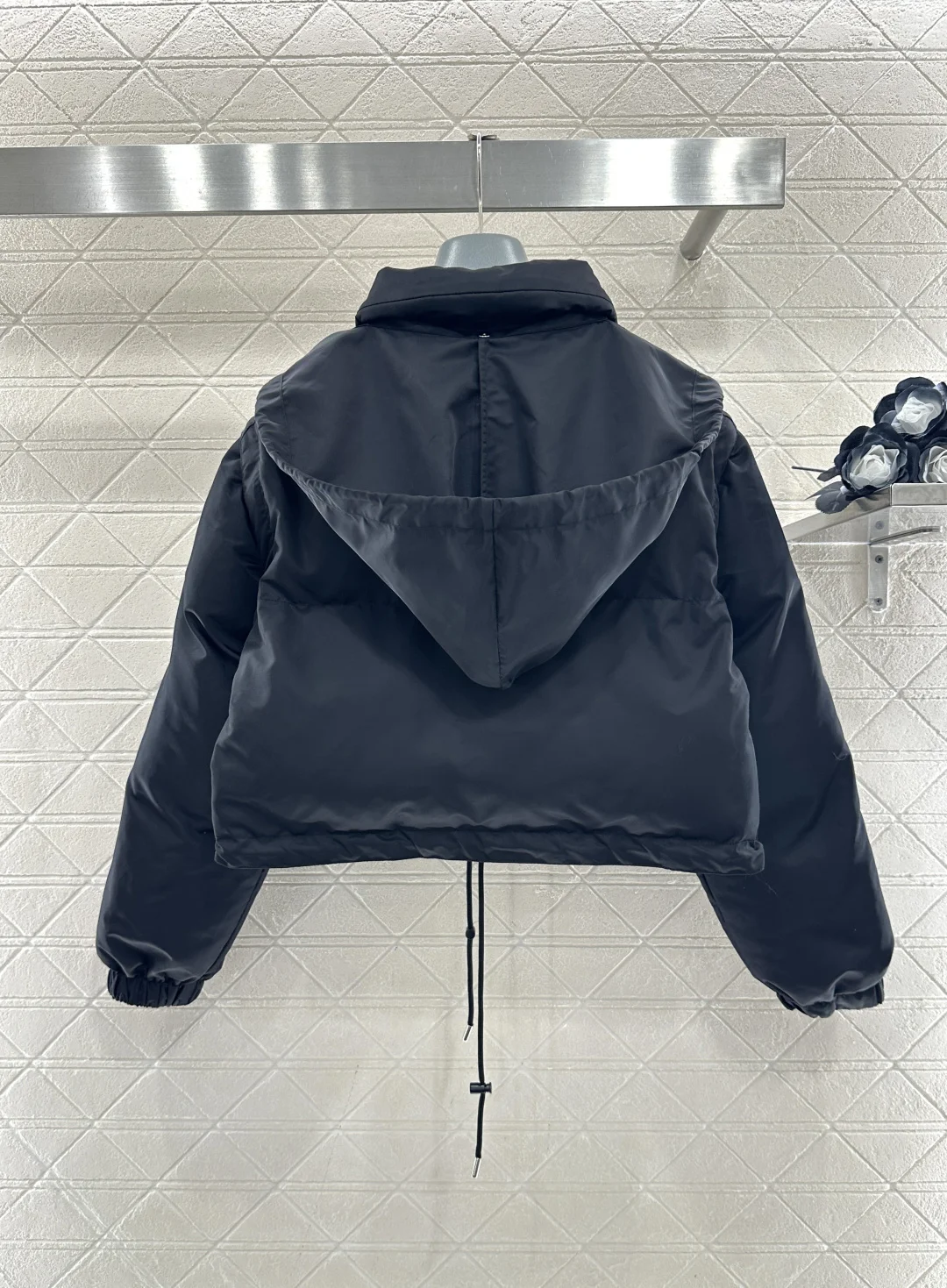 

A black glossy short detachable two-wear down jacket with drawstring hem, a high-end and trendy everyday streetwear coat