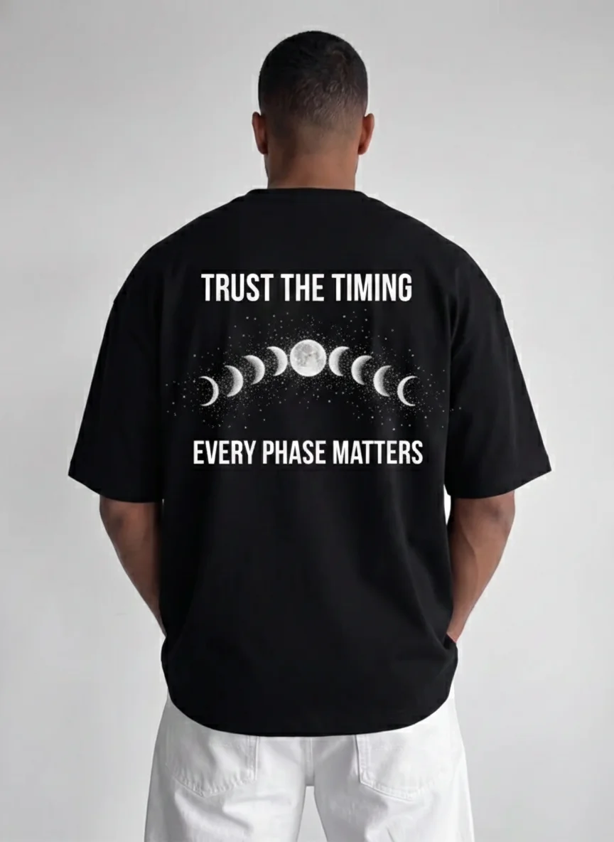 

Black Moon Phases Graphic Tee with Text Trust the Timing Every Phase Matters Back Print Celestial Lunar Design in White Ink