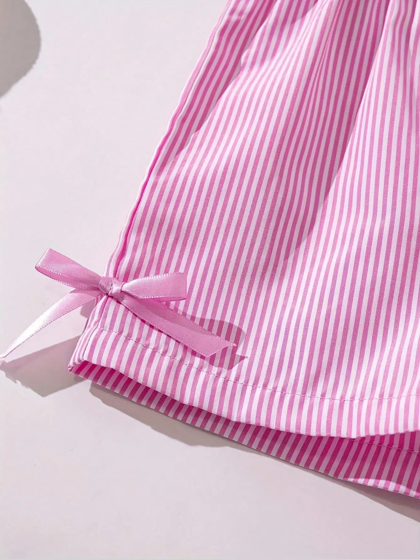 Modisches zweiteiliges Set für Mädchen: rosa-weiß gestreifter Rundhalspullover mit Schnürung, Schleife und Rüschenrand + rosa gestreifte Schmetterlings-Shorts. – Detail 12
