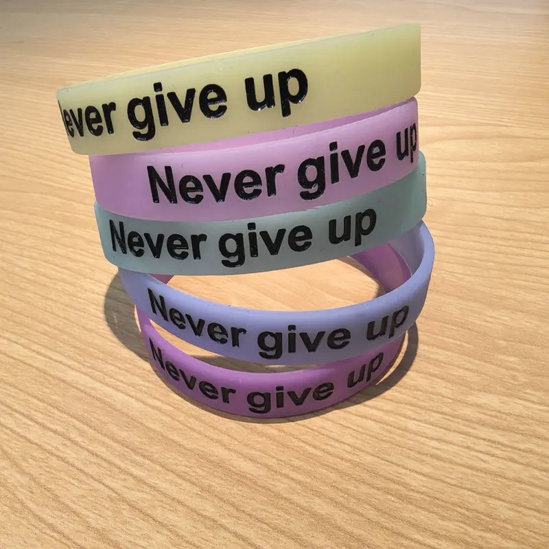 سوار معصم من السيليكون المتوهج في الظلام مع طباعة "لا تتخلى أبدًا" - سوار رياضي تحفيزي، مريح ومتين، متعدد C