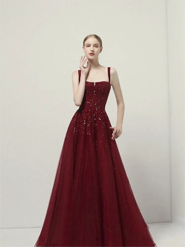 A luxurious beaded wine red banquet dress with strappy design for toasting