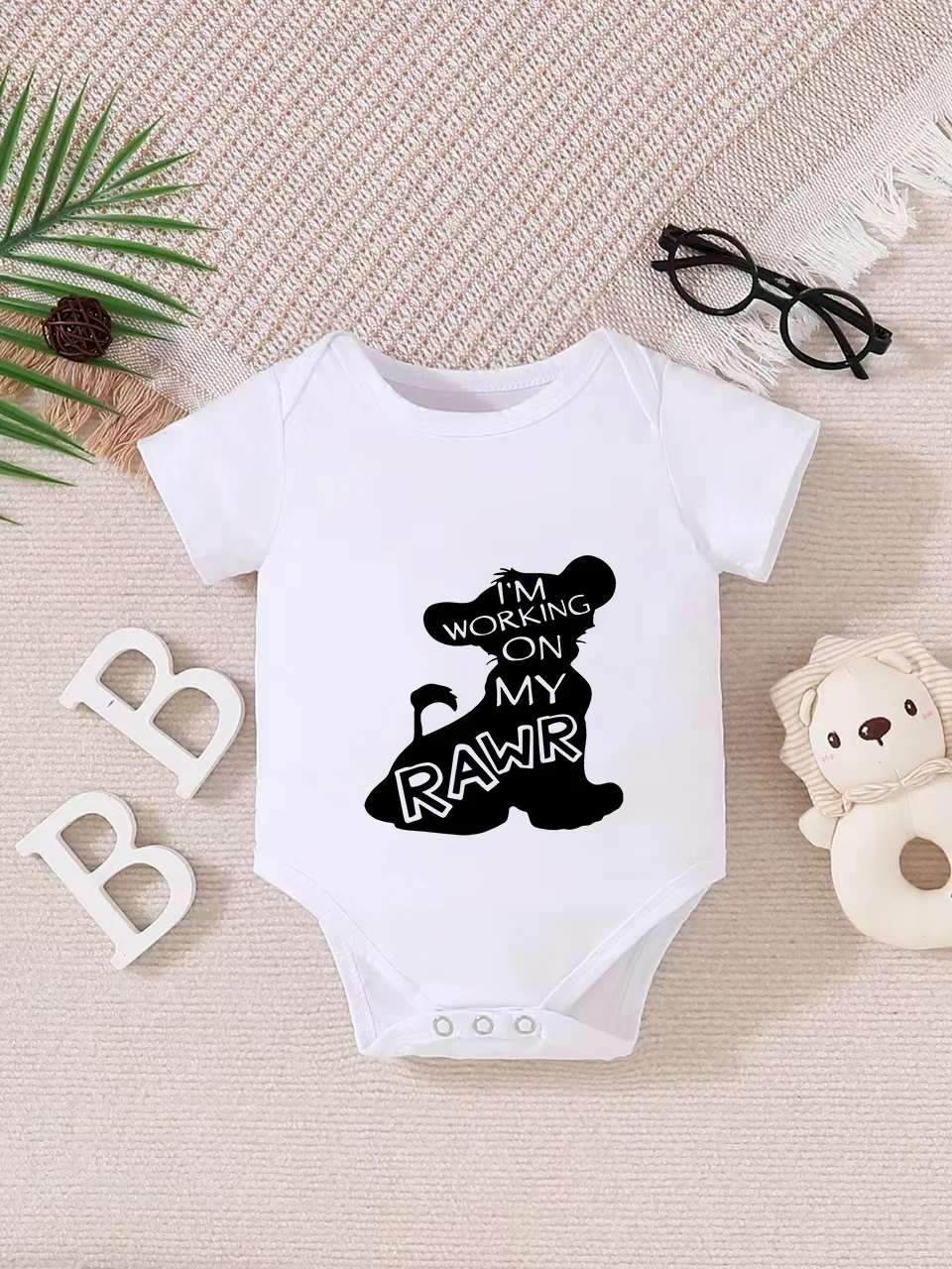 Playful letter-printed baby short-sleeve triangle bodysuit. Button closure for easy dressing, machine washable