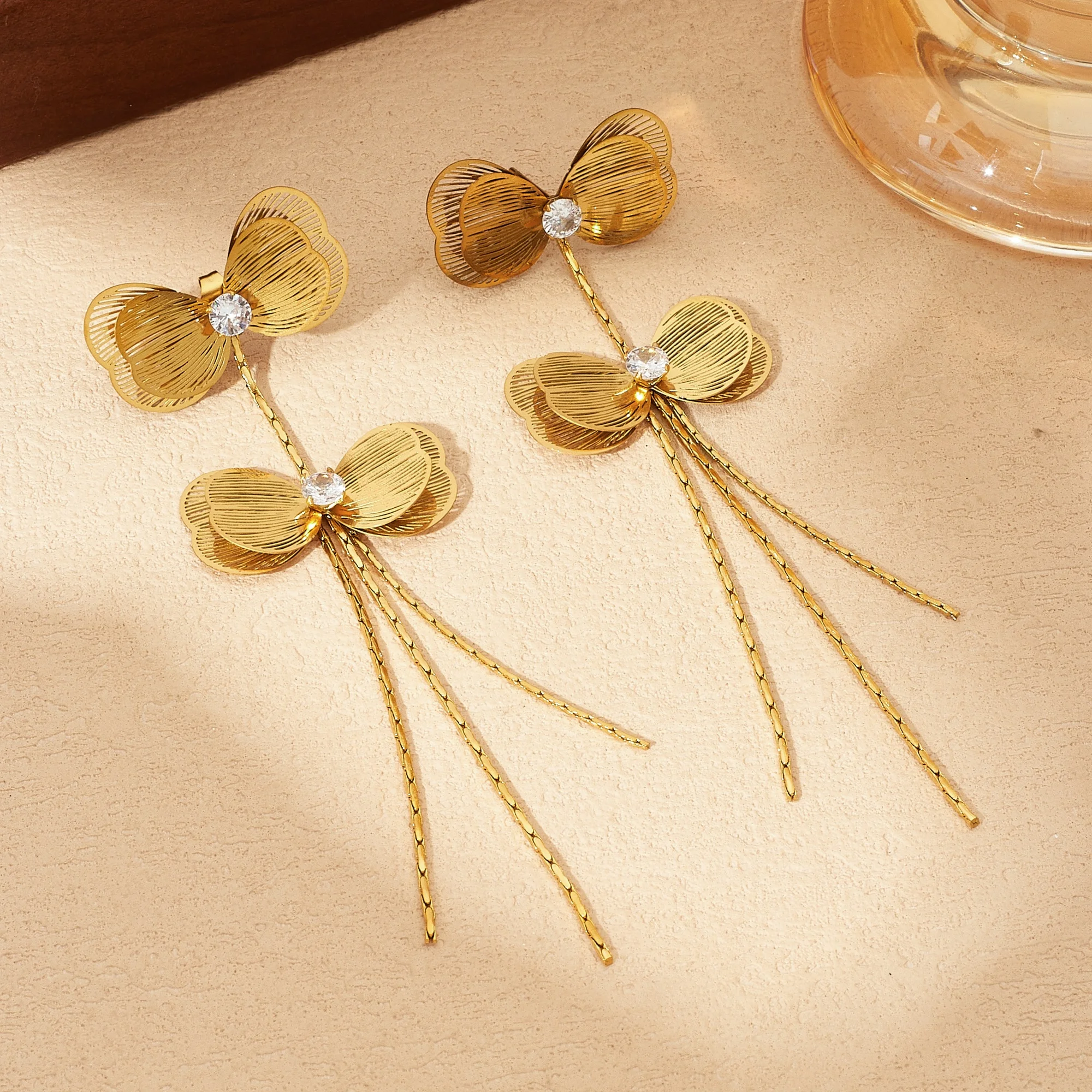 Edelstahl Goldene Doppel-Schleife mit Strass-Einlage Lange Quasten-Ohrringe Damen Ausgehöhlte Schleifen-Ohrringe Schmuck
