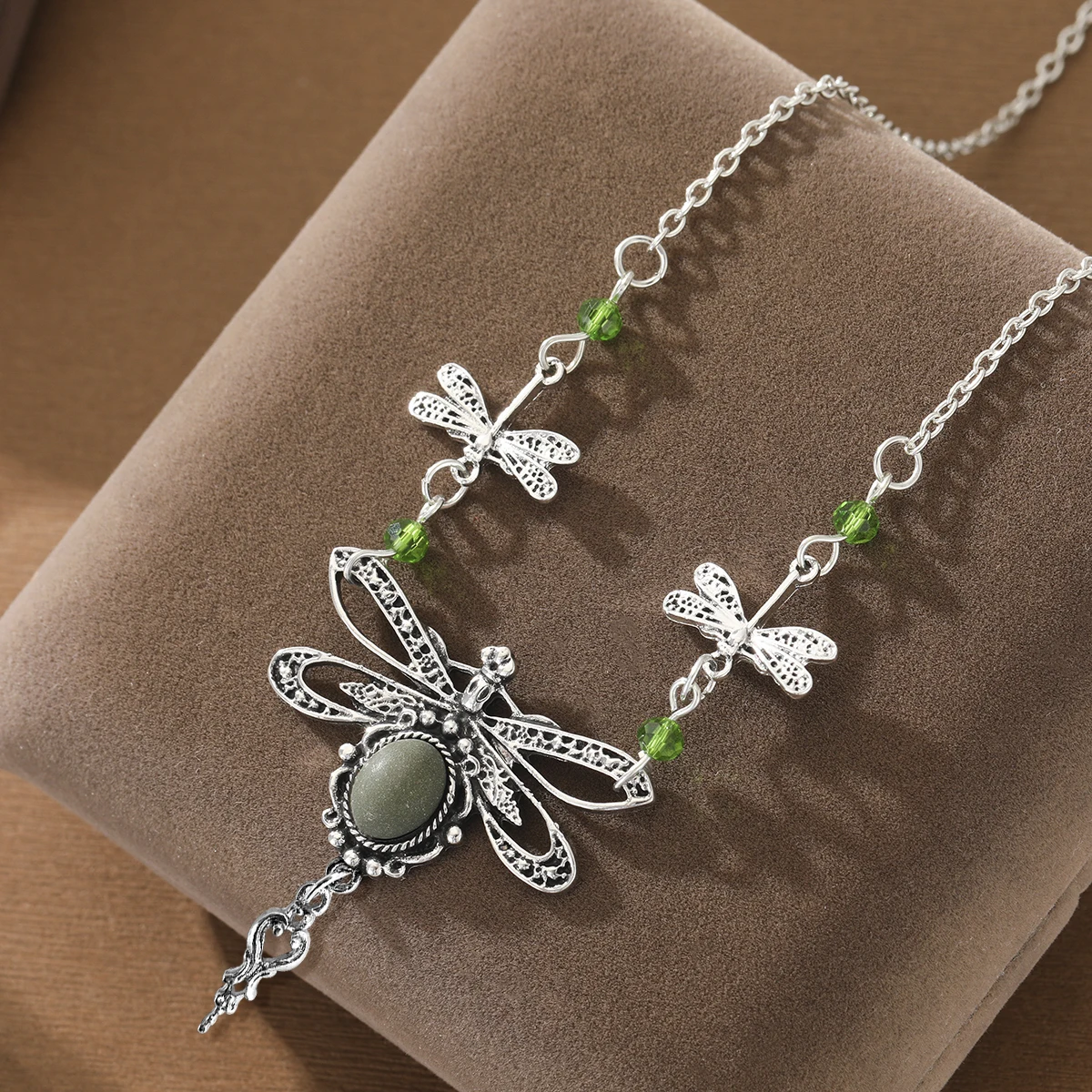 A necklace featuring ethnic-style small dragonflies arranged in a row, paired with an artificial gemstone pendant for the lady.