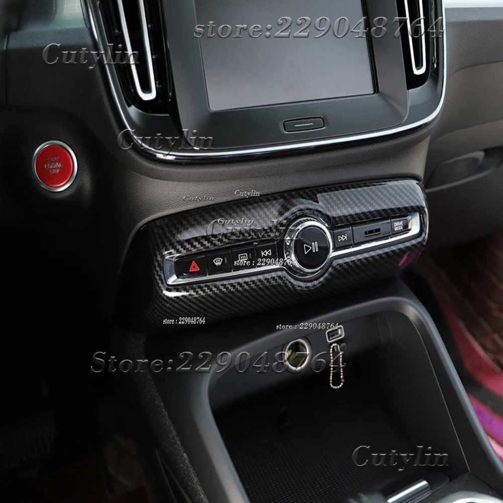 Kit de molduras interiores Volvo XC40 de fibra de carbono 2019-2021 con moldura de consola central con textura de fibra de carbono negro y acentos cromados alrededor de los controles de audio y la zona del cambio de marcha.
