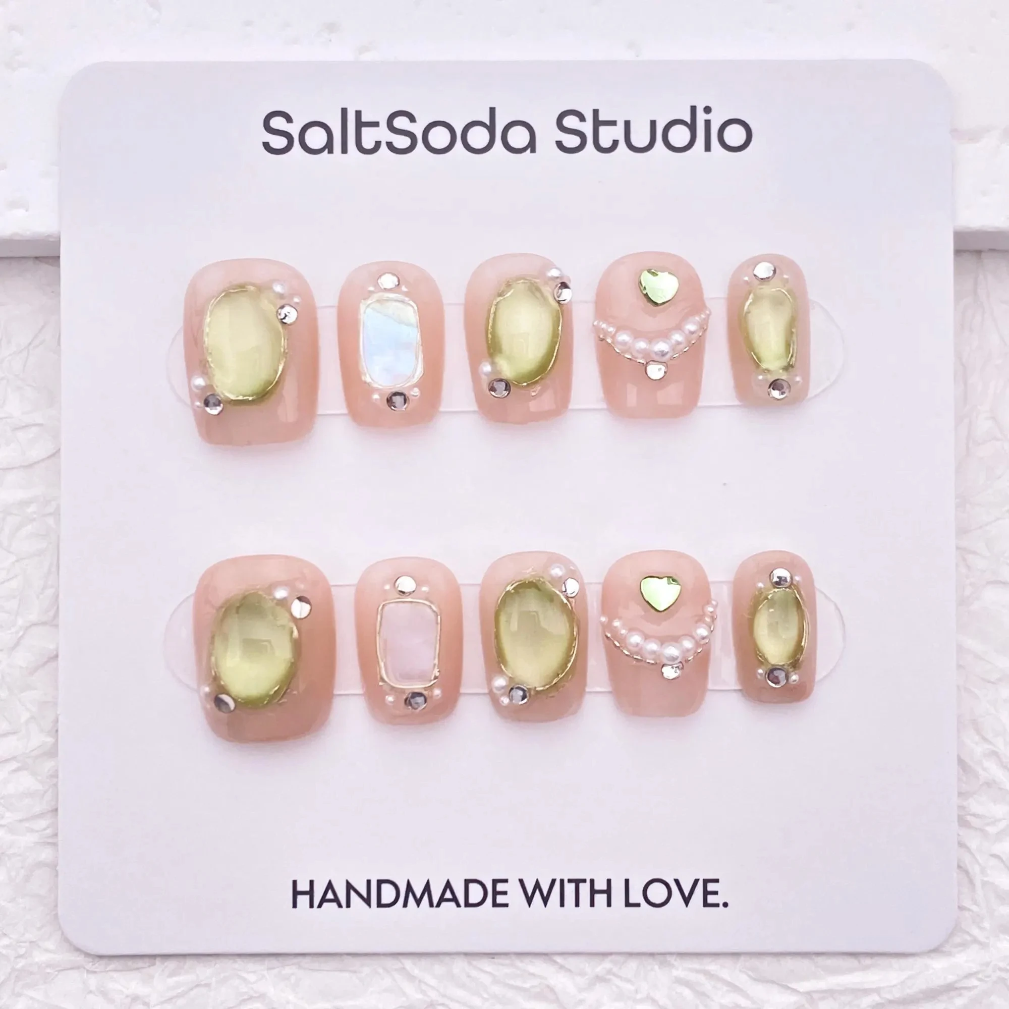 

Cute light pink nail art with shimmering green cat-eye pearls, press-on nail art, high-quality reusable nail art.