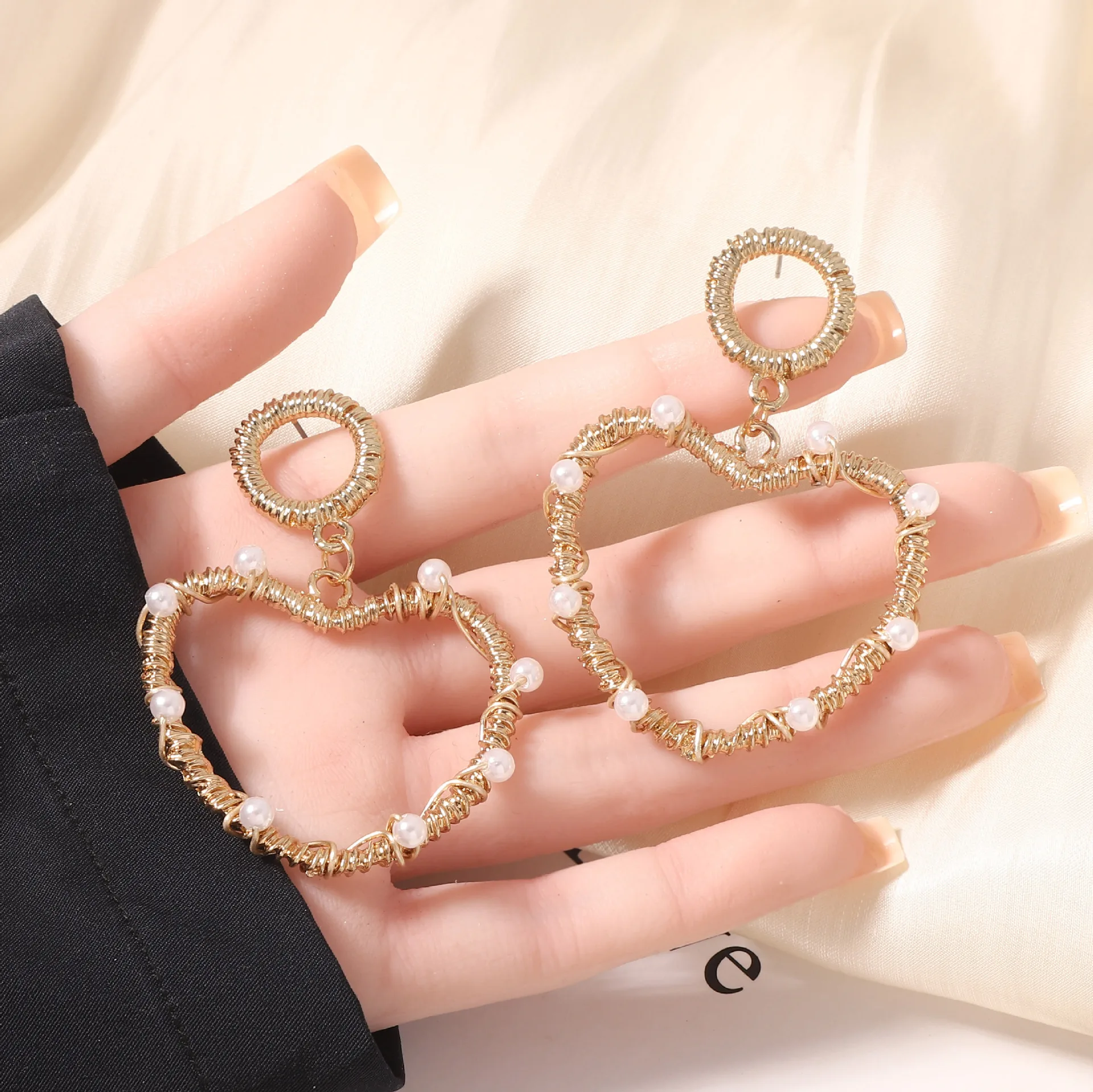 Classic popular heart-shaped pure hand-wound hollow imitation pearl love earrings, fashionable and versatile