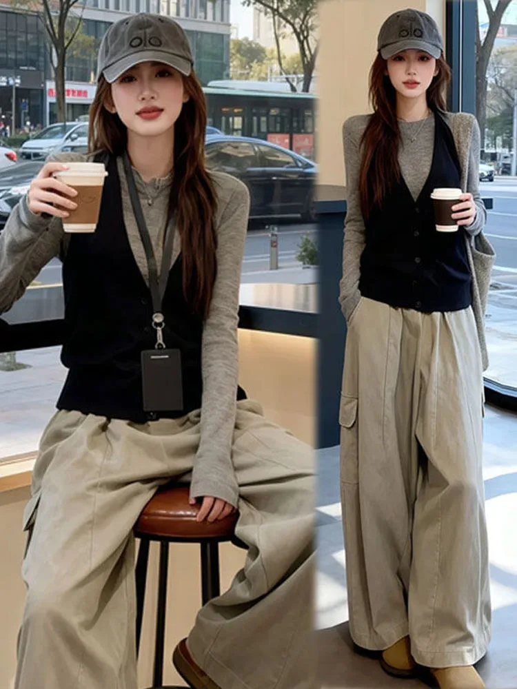 

Повседневный комплект из трех предметов: женская футболка с длинным рукавом и V-образным вырезом, черный жилет и модные рабочие брюки. Весна 2026.