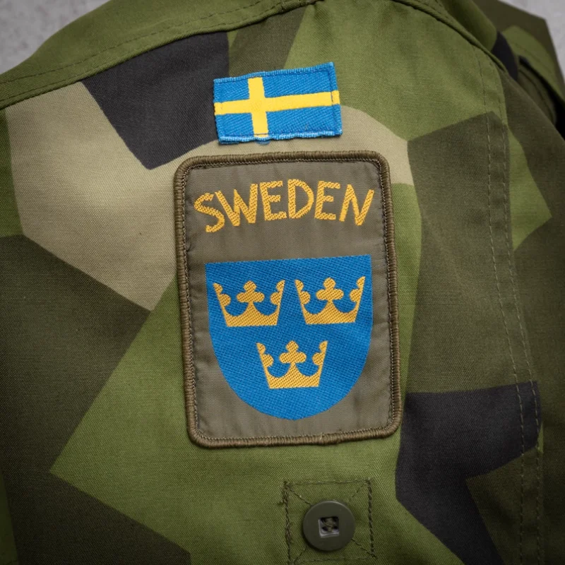 

Шведская военная версия M90, камуфляжная эмблема национального флага, повязка на руку, три эмблемы императорской короны