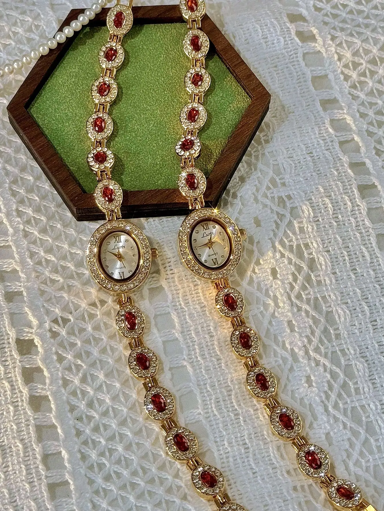 

Элегантные женские часы золотистого цвета с красными камнями и вставками из фианитов, овальный циферблат, водонепроницаемость 30 м.