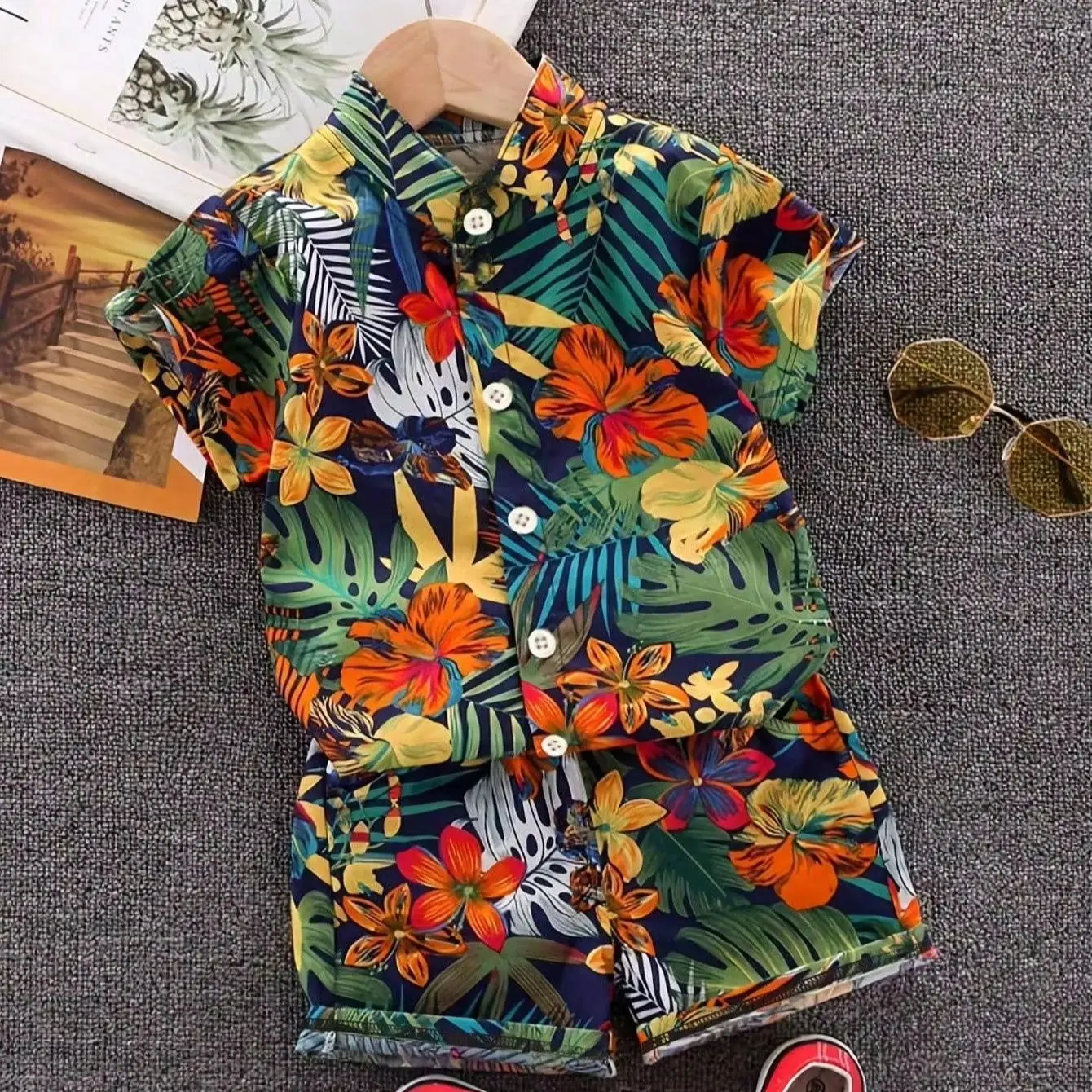 Sommerliches Kinder-Set mit tropischem Blatt- und Blumenmuster, bestehend aus einem kurzärmeligen Hemd mit Stehkragen und passender Shorts. – Detail 1