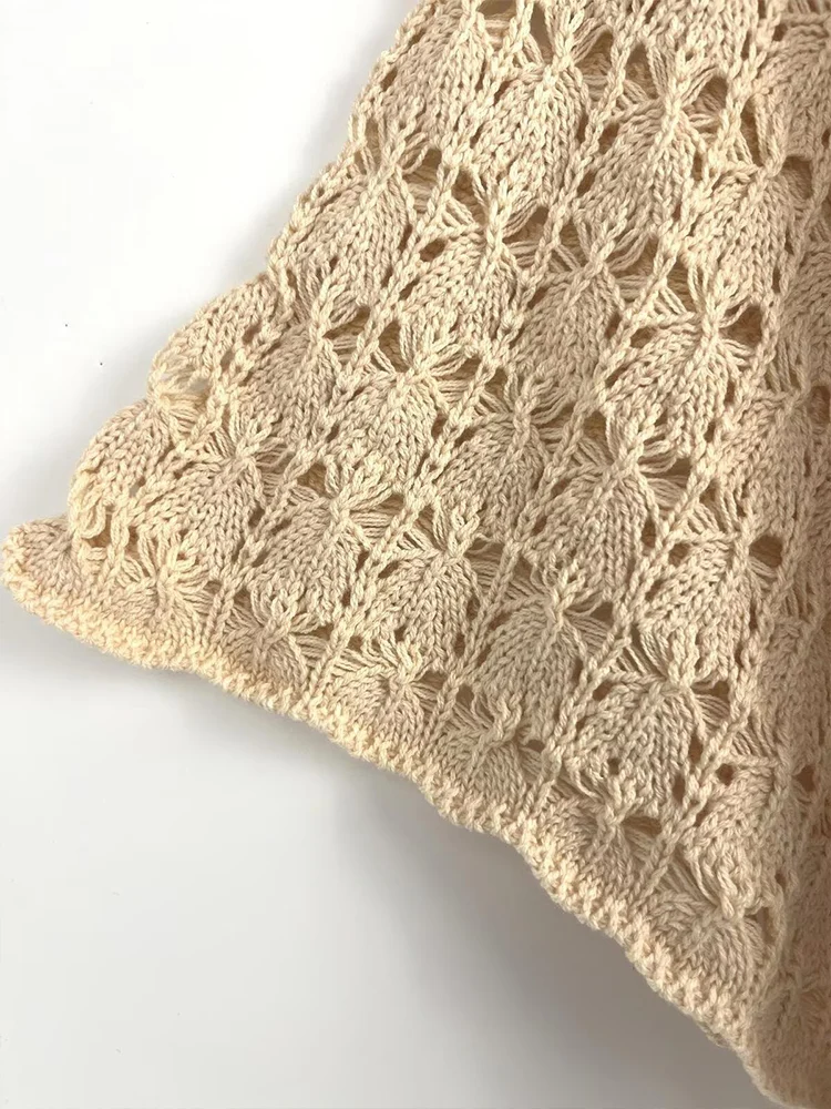 Europejskie i amerykańskie trendy jesiennej kolekcji damskiej: dzianinowy kardigan z krótkim rękawem, dekoltem w serek, sznurowaniem i łączonych elementów.