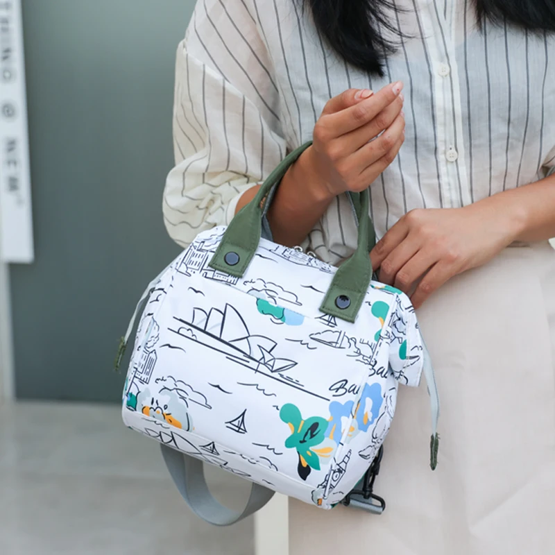 A lady carrying a large-capacity mummy bag, cartoon graffiti Halloween printing patterns, suitable for daily use with a baby out