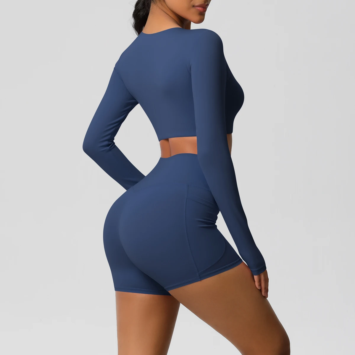 ชุดโยคะผู้หญิง ชุดออกกำลังกาย สีพื้น ทรงเข้ารูป แขนยาว แห้งเร็ว กางเกงขาสั้นฟิตเนสทรงพีชบัตต์เทิ้ล มีกระเป๋า