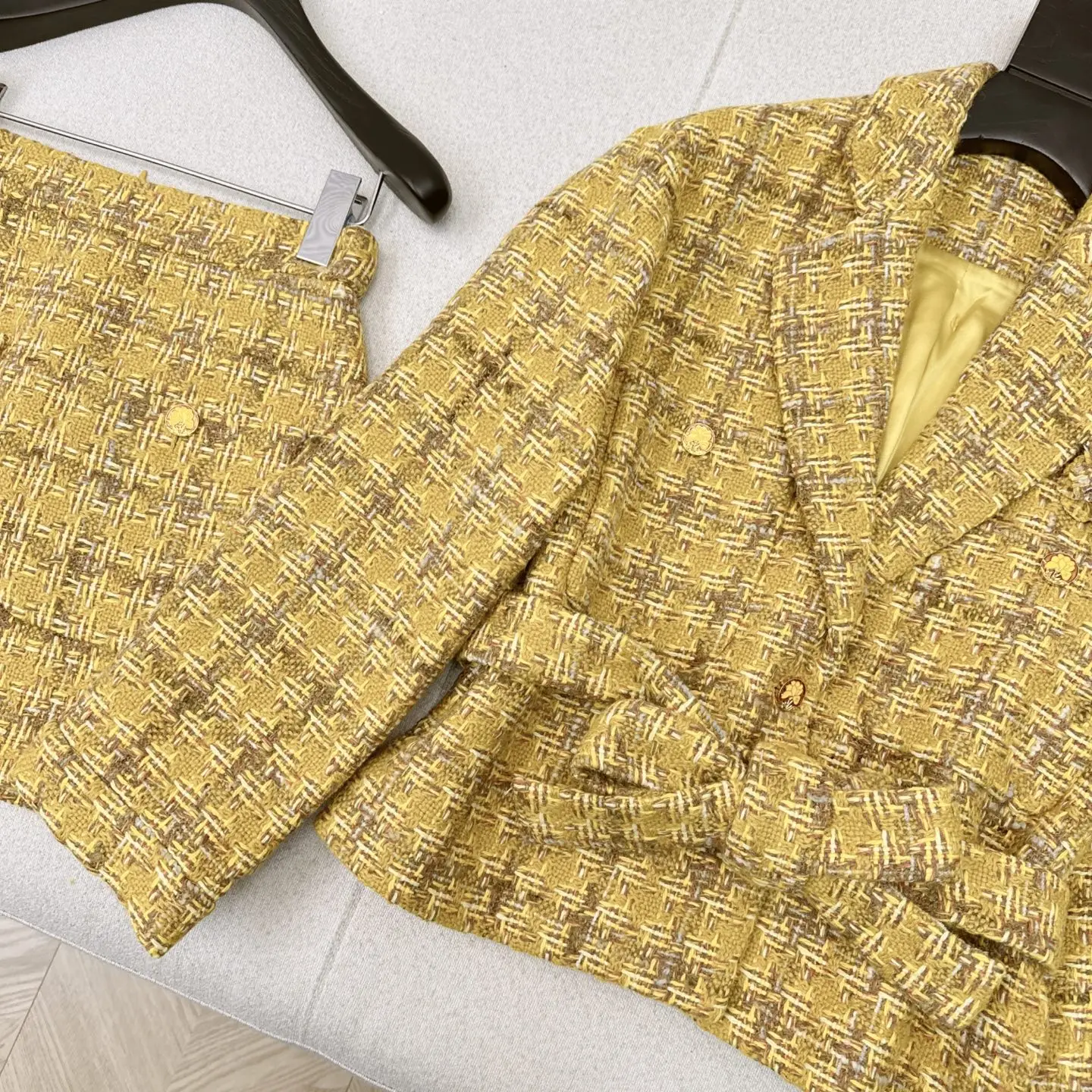 El último conjunto de temperamento de alta sociedad para otoño e invierno de 2025, con chaqueta tejida con decoración floral y falda acampanada.