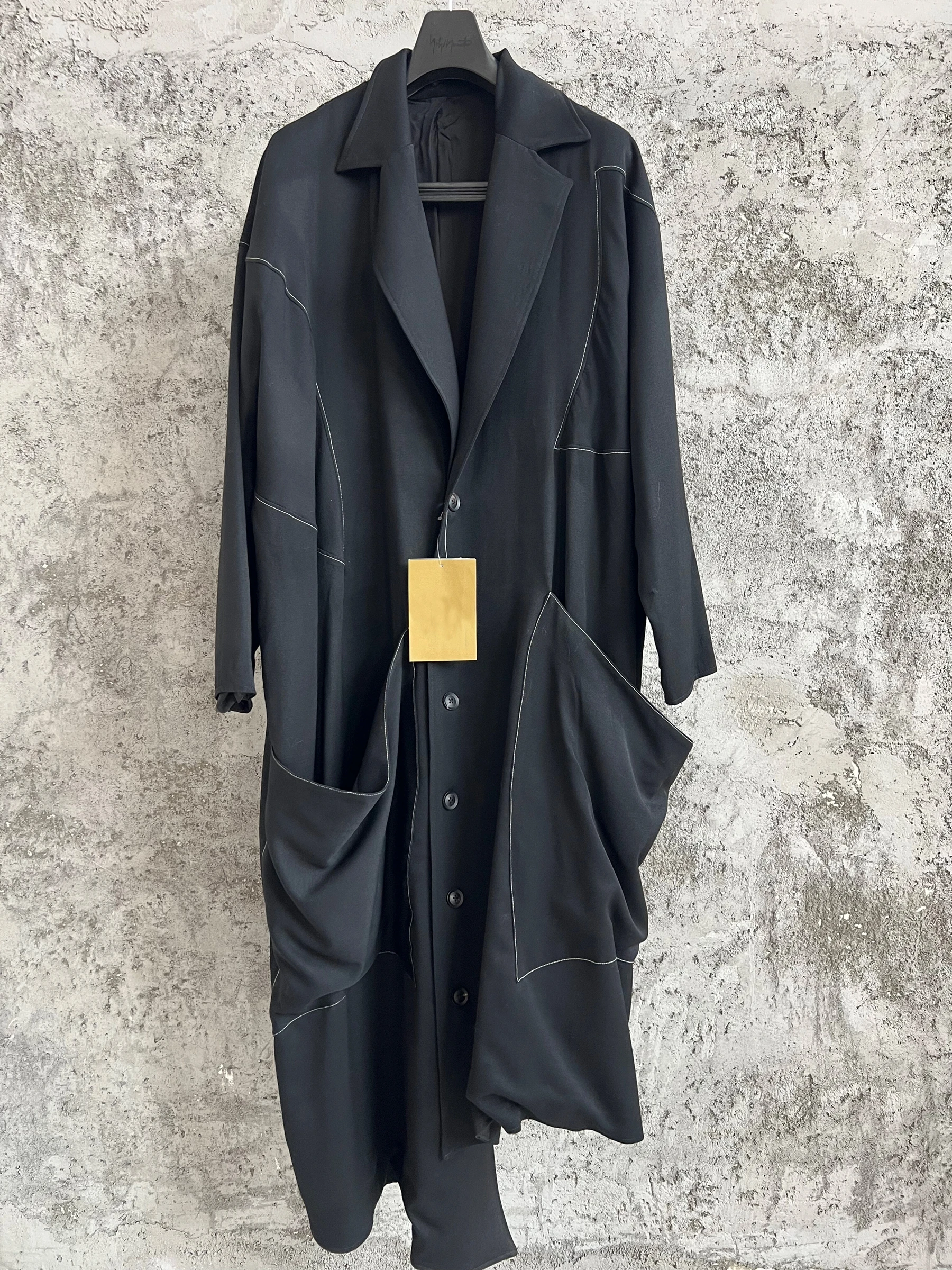 

TOP-YAMAMOTO, a niche designer of mid-length trench coats made of pure wool with fringed edges