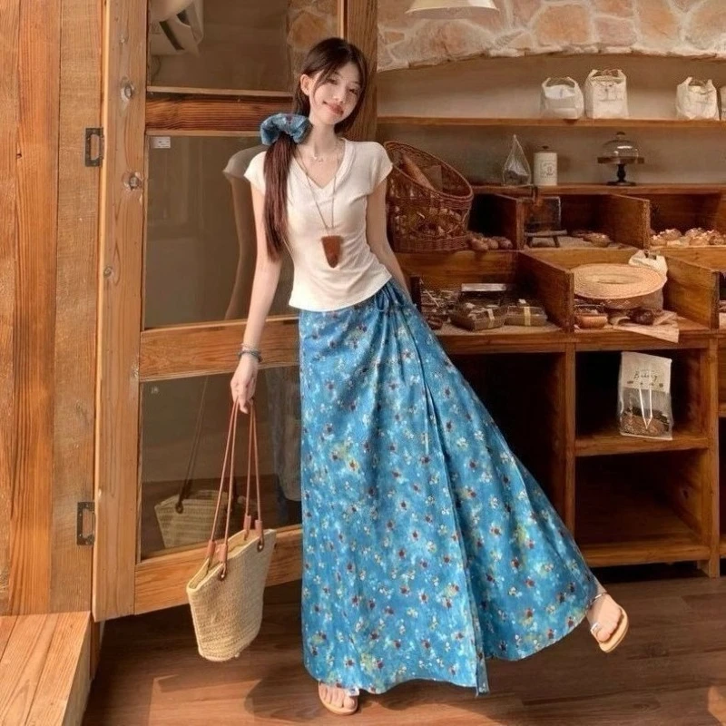 

Женский летний комплект из двух предметов: синяя юбка с цветочным принтом в стиле масляной живописи и топ с V-образным вырезом и коротким рукавом, простой, стройнящий крой.