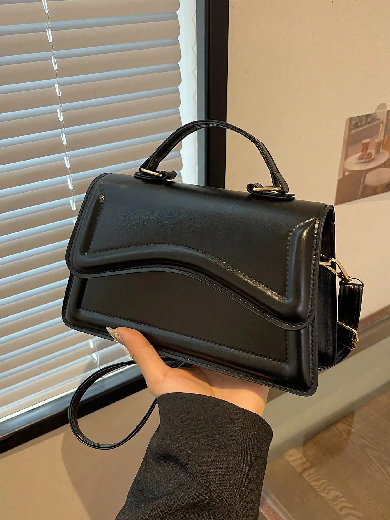 

Минималистичная черная структурированная сумка-кроссбоди с волнистым клапаном и золотистой фурнитурой