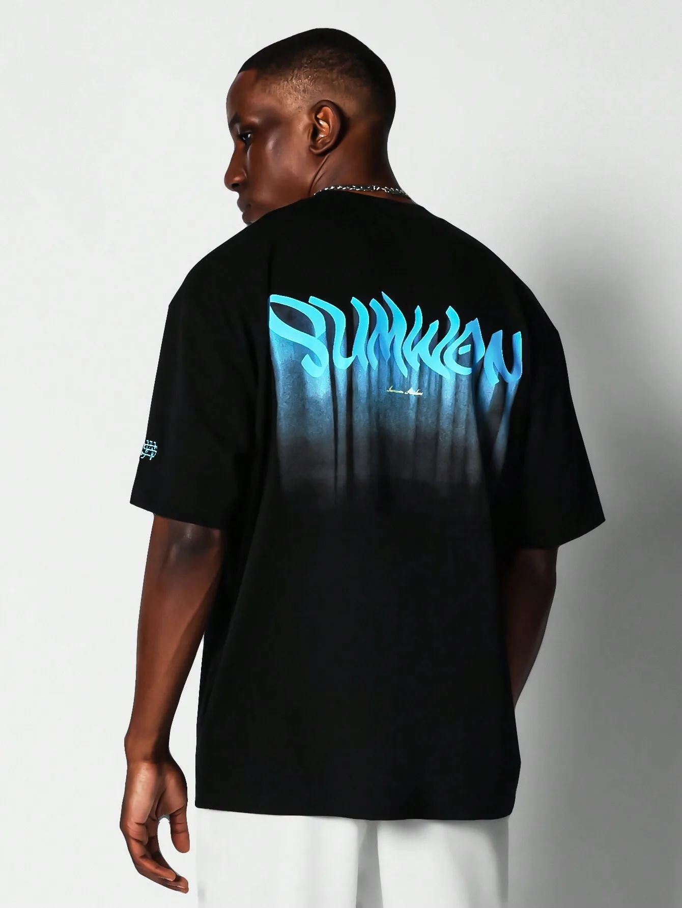 

Черная футболка оверсайз с коротким рукавом и синим граффити-принтом