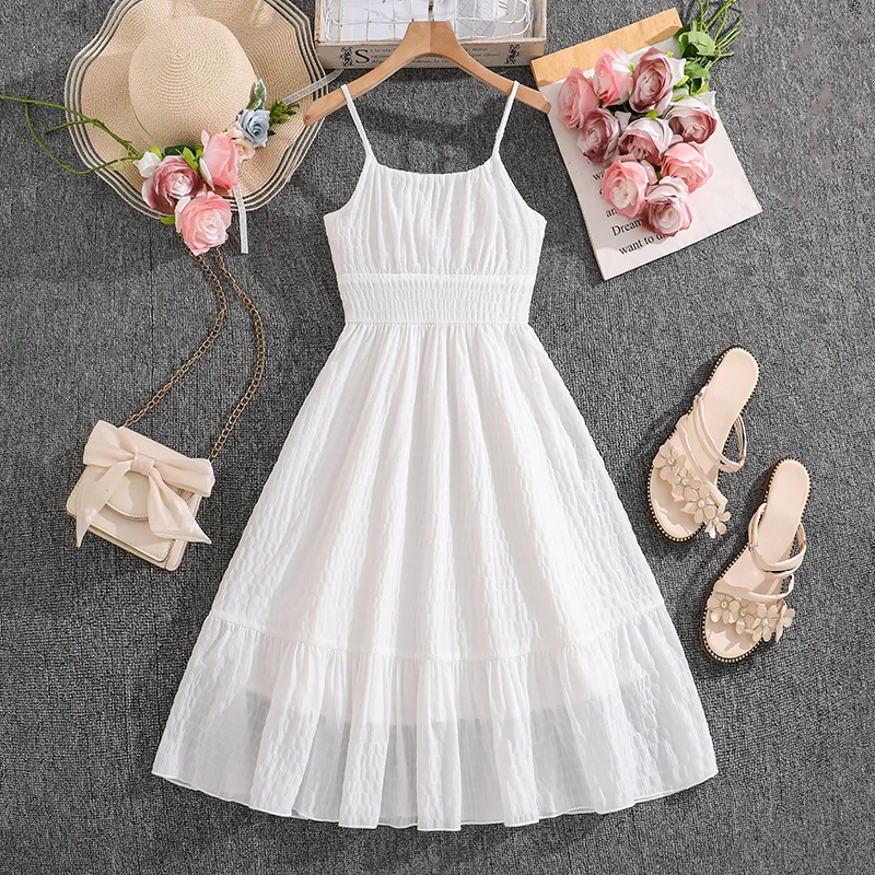 

Повседневное детское платье для девочек 8-12 лет: белое, фактурное, с тонкими бретелями спереди, присборенной талией, сетчатым подолом с оборками и присборенным лифом сзади.