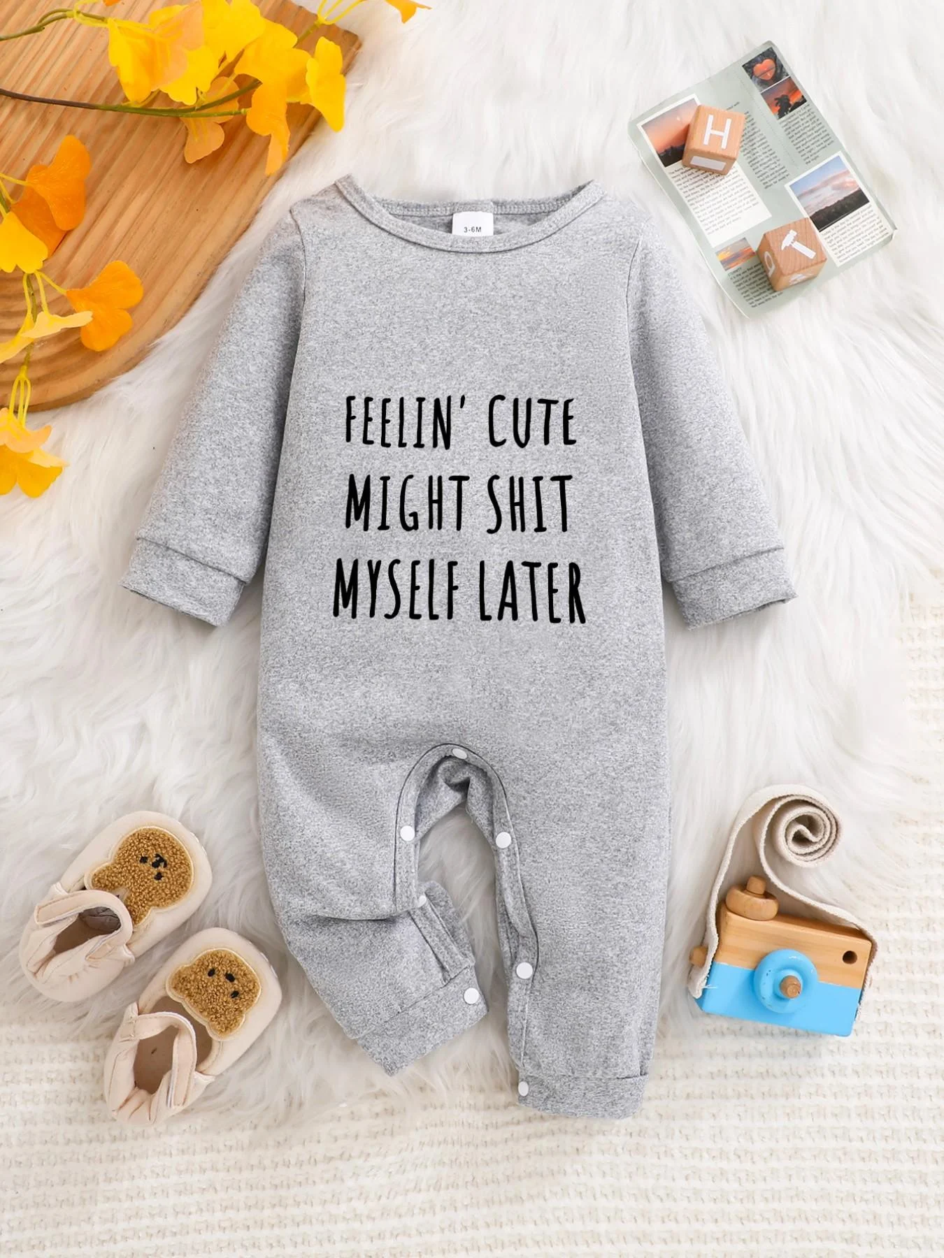 A baby long-sleeved onesie with interesting letter prints. It features a buttoned design for easy putting on and taking off, and