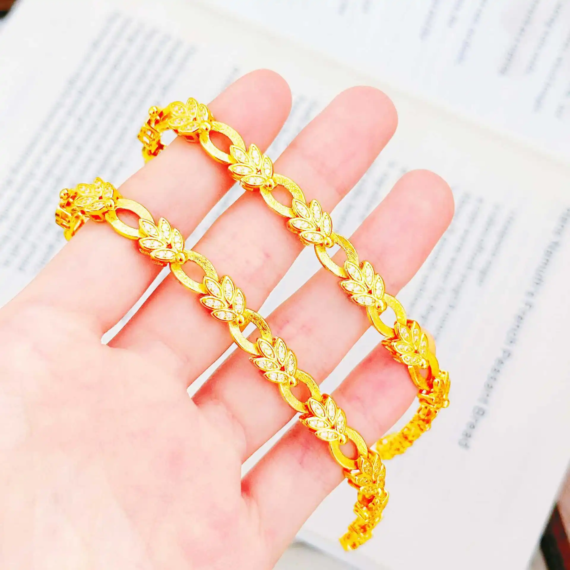 

Luxurious 24K gold leaf bracelet with diamond inlay, featuring a yellow clip buckle design, exuding a touch of light luxury