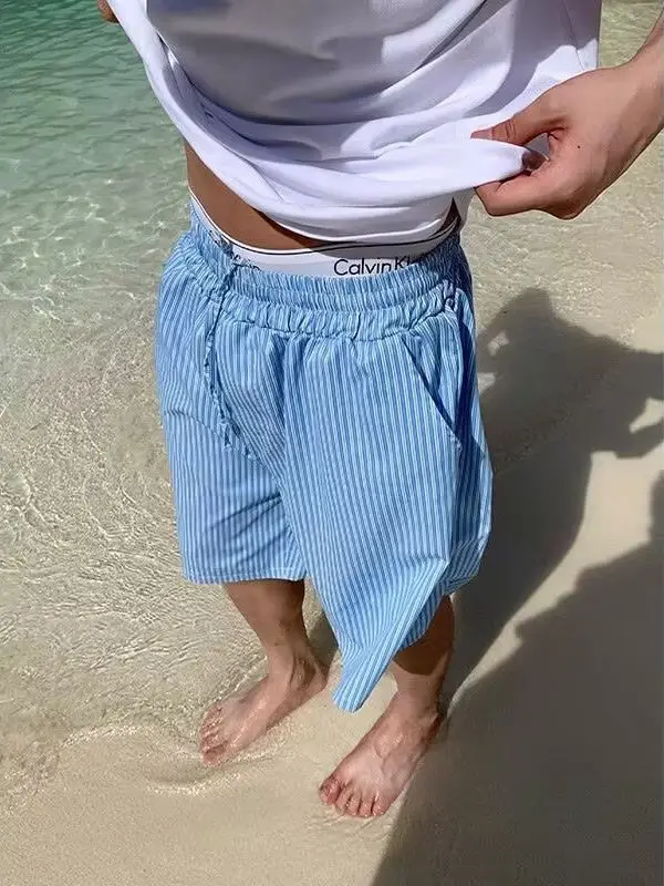 

Широкие летние шорты унисекс синего цвета в полоску, свободного кроя, с эластичным поясом, длина до колена