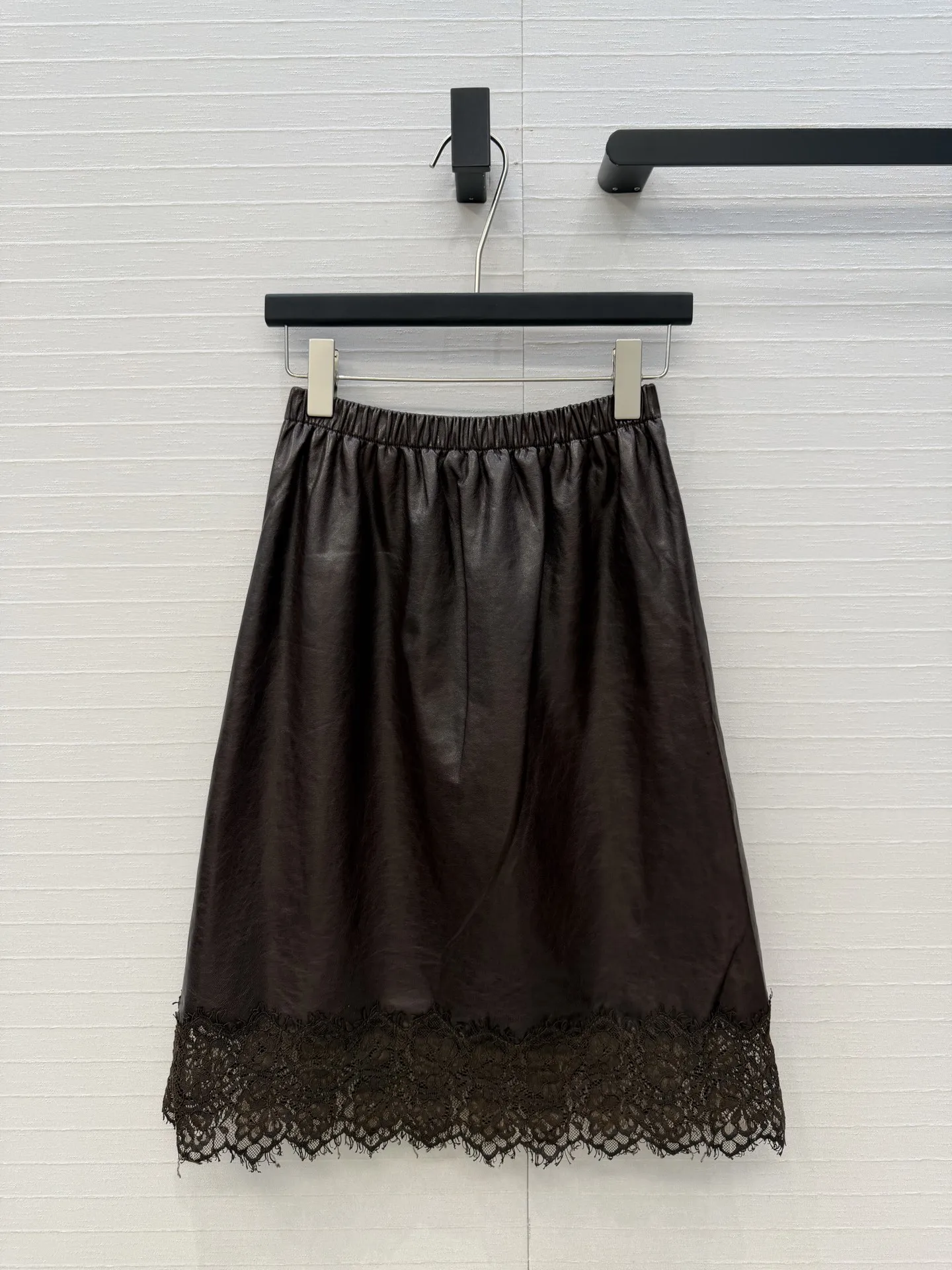 Dark brown elastic waist half length skirt with lace stitching at the hem for a slimming effect, covering the hips