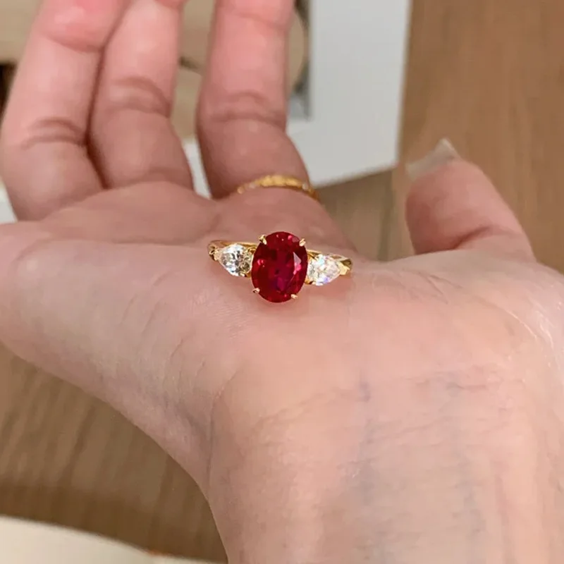 

Classic Three Stone Imitation Red Zircon Pigeon Egg Ring 2026 Light Luxury Gold Plated Ring For Women Commute Versatile Finger R
