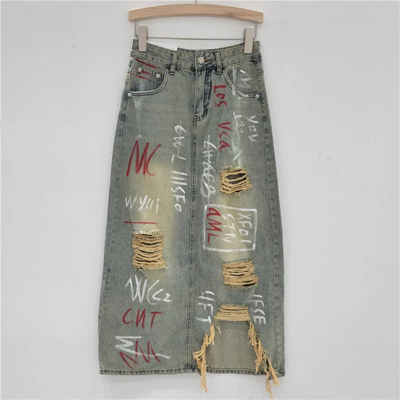 

Vintage Denim Skirt. High-waist A-line with a front slit & edgy graffiti print. The 2025 statement piece.