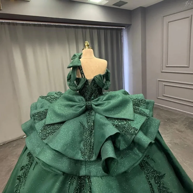 فستان Quinceanera باللون الأخضر الداكن اللامع عاري الكتفين من الدانتيل اللامع بفيونكة طويلة بذيل فيستدوس دي 15 Quinceanera ﻿ تخصيص